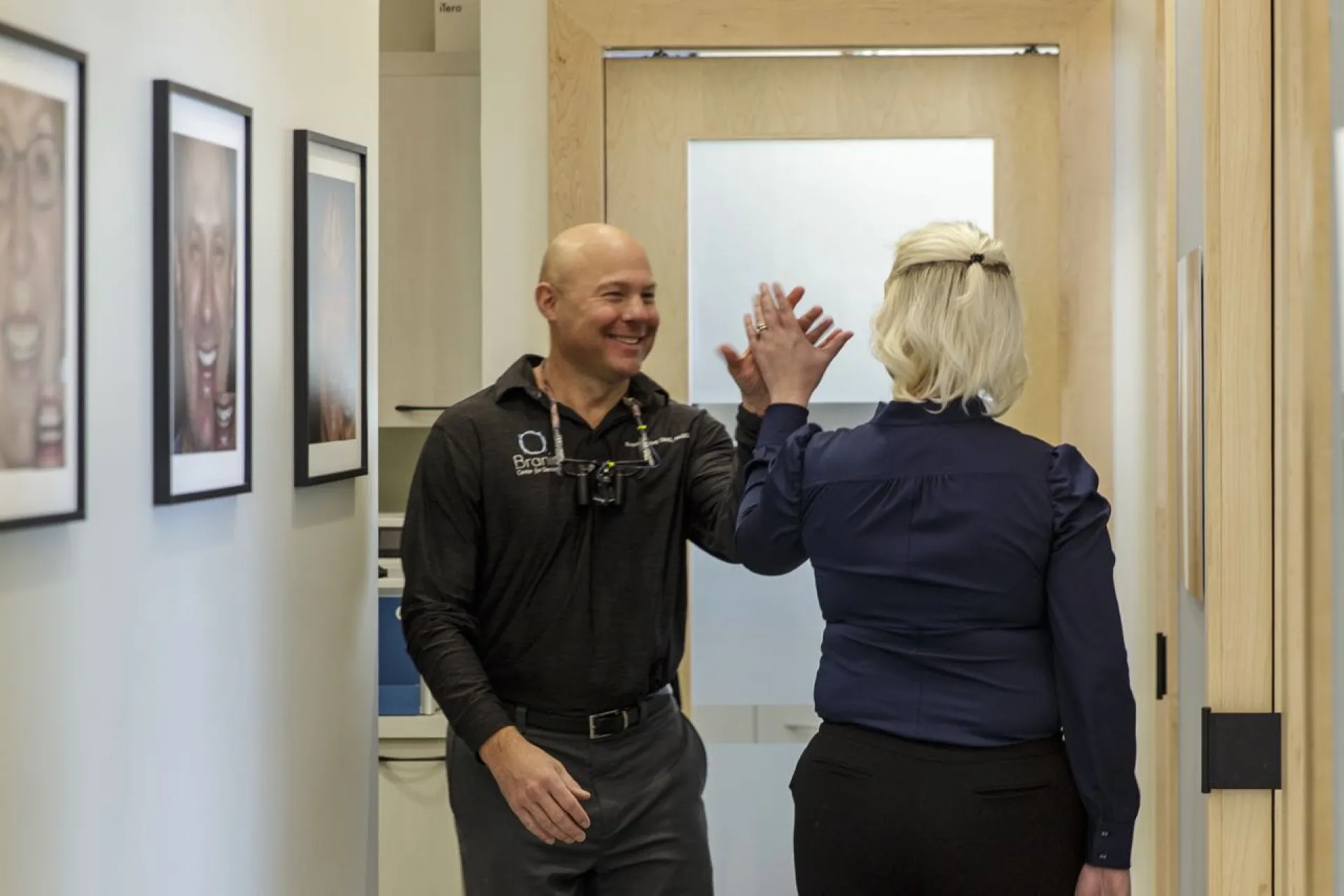 Two doctors high fiving in the hallway