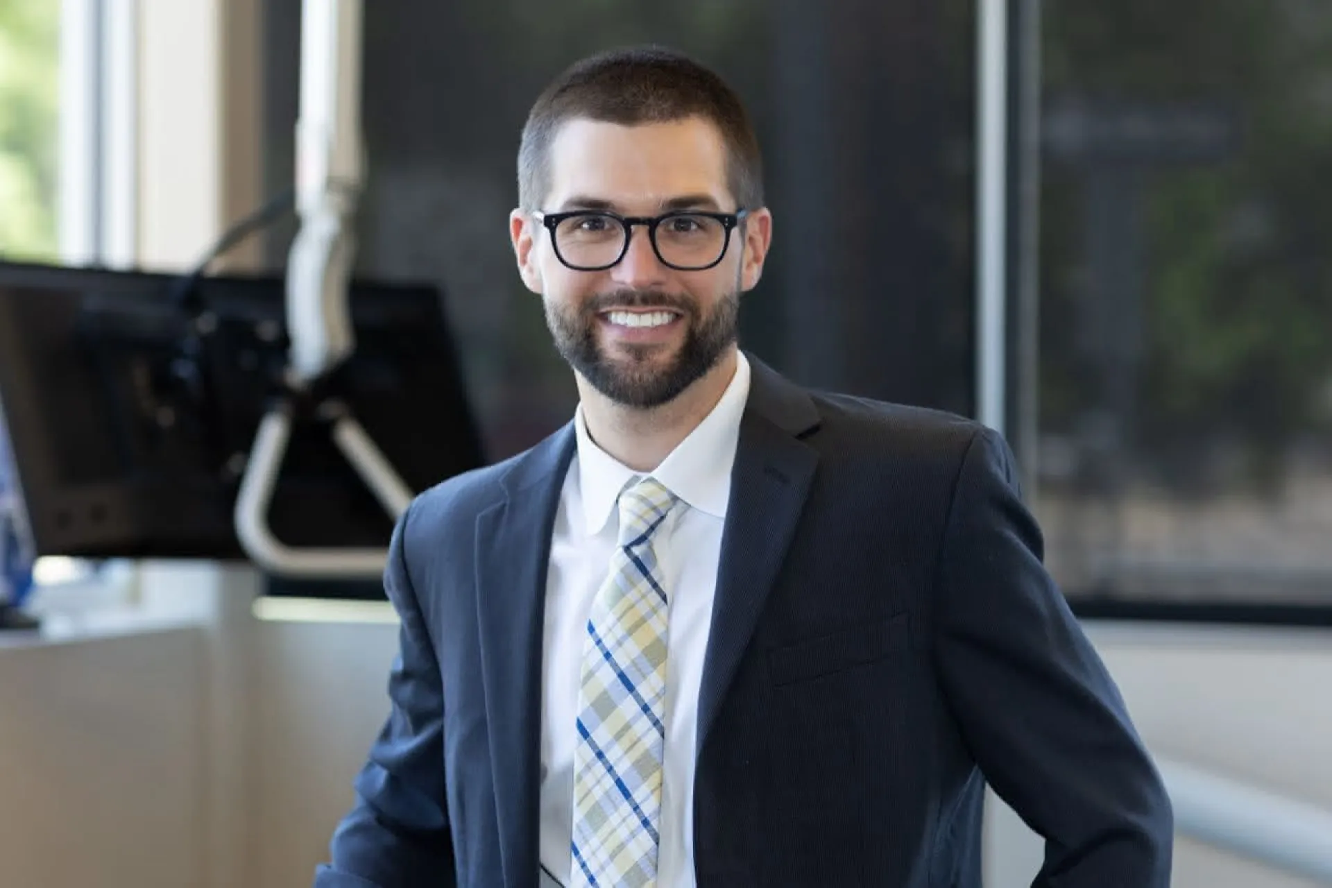 Dr. Adam Staffen in a suit smiling