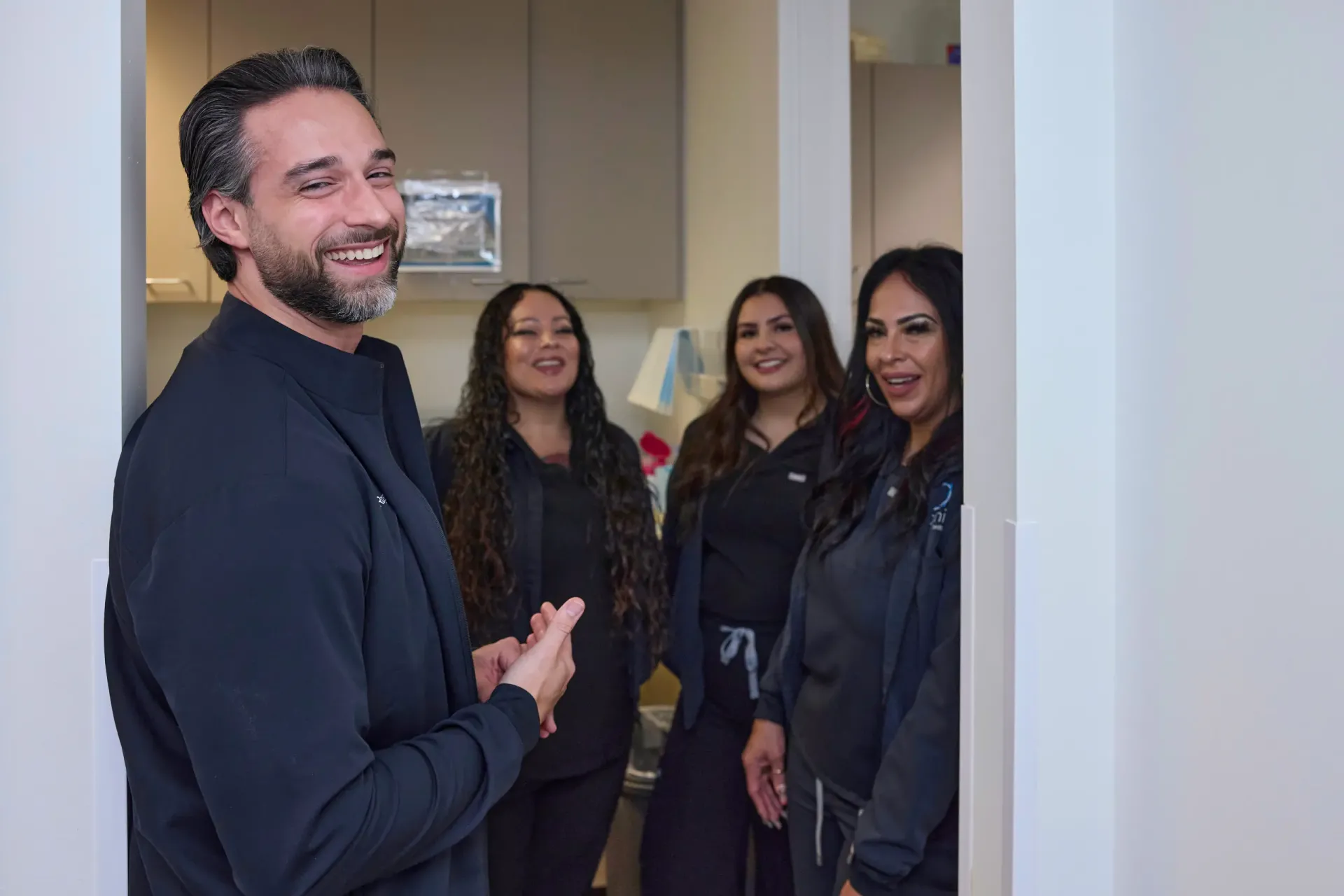 A doctor in a doorway with team