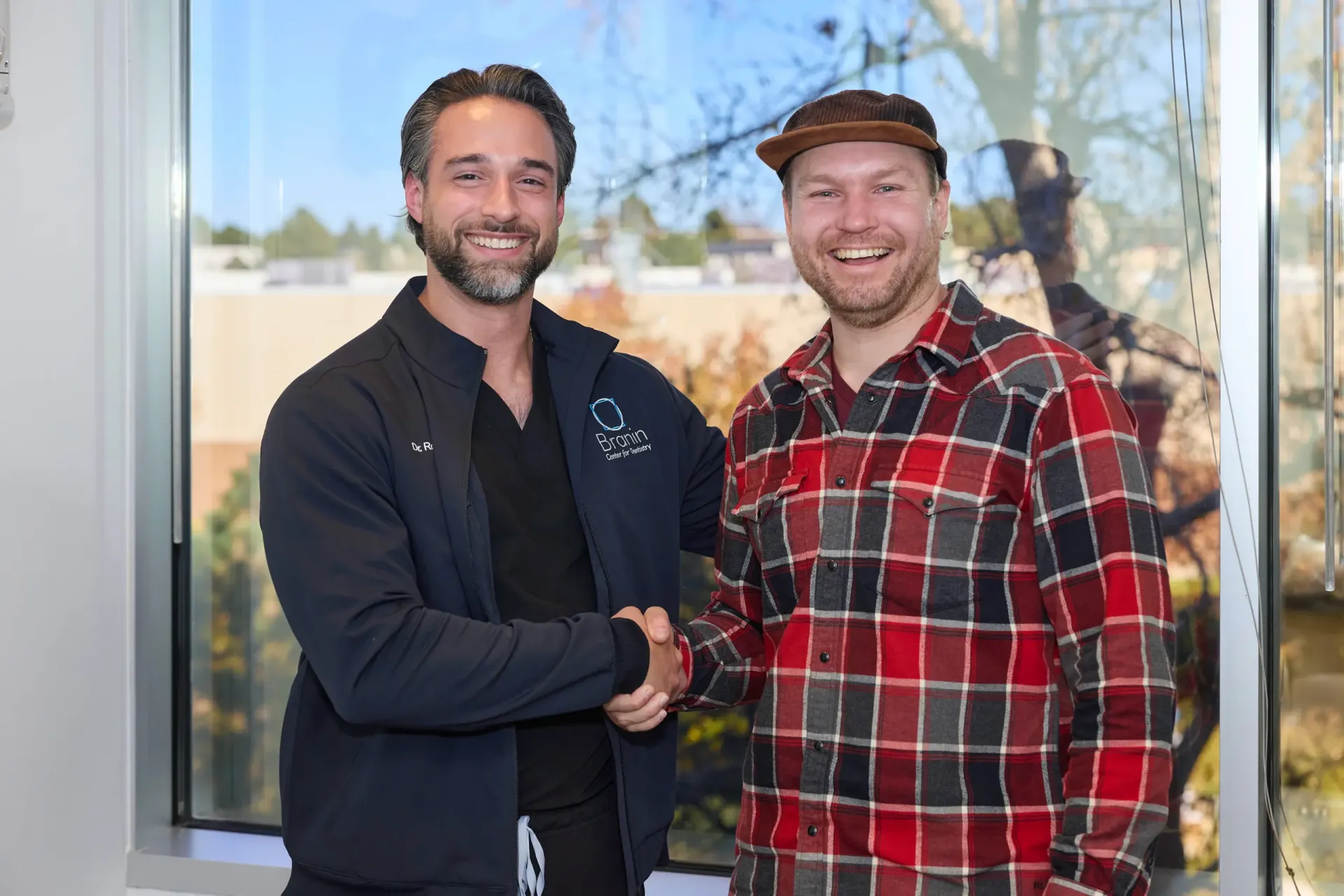 A doctor with a patient in a plaid shirt