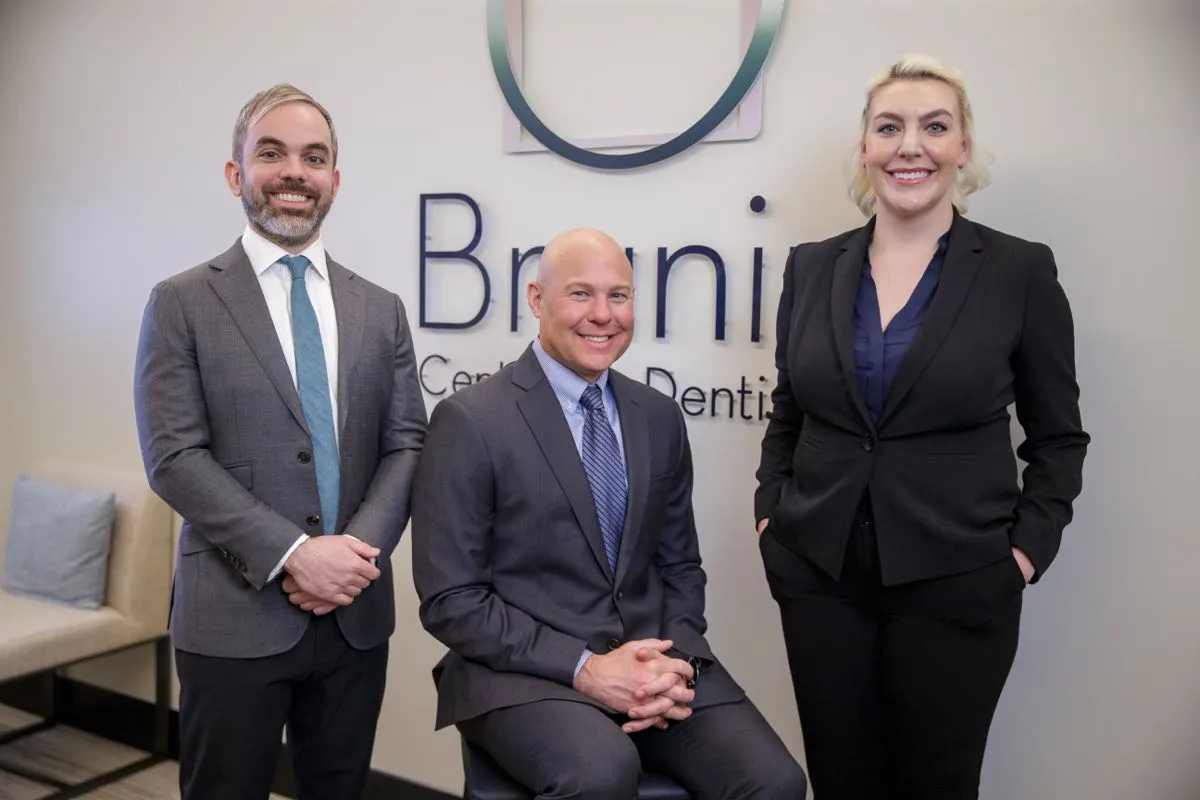 Our doctors posing in front of our logo