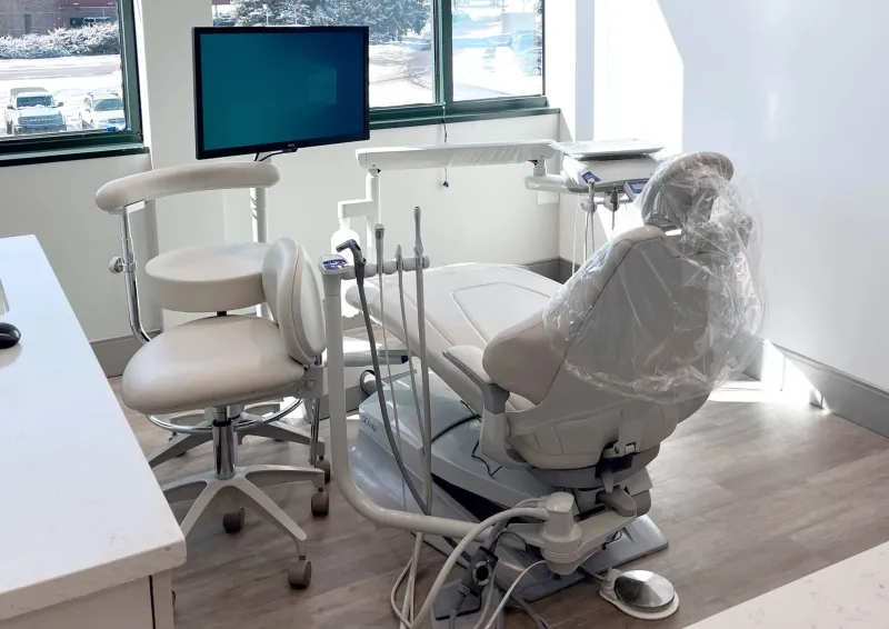 A white dentist chair in a neutral colored room
